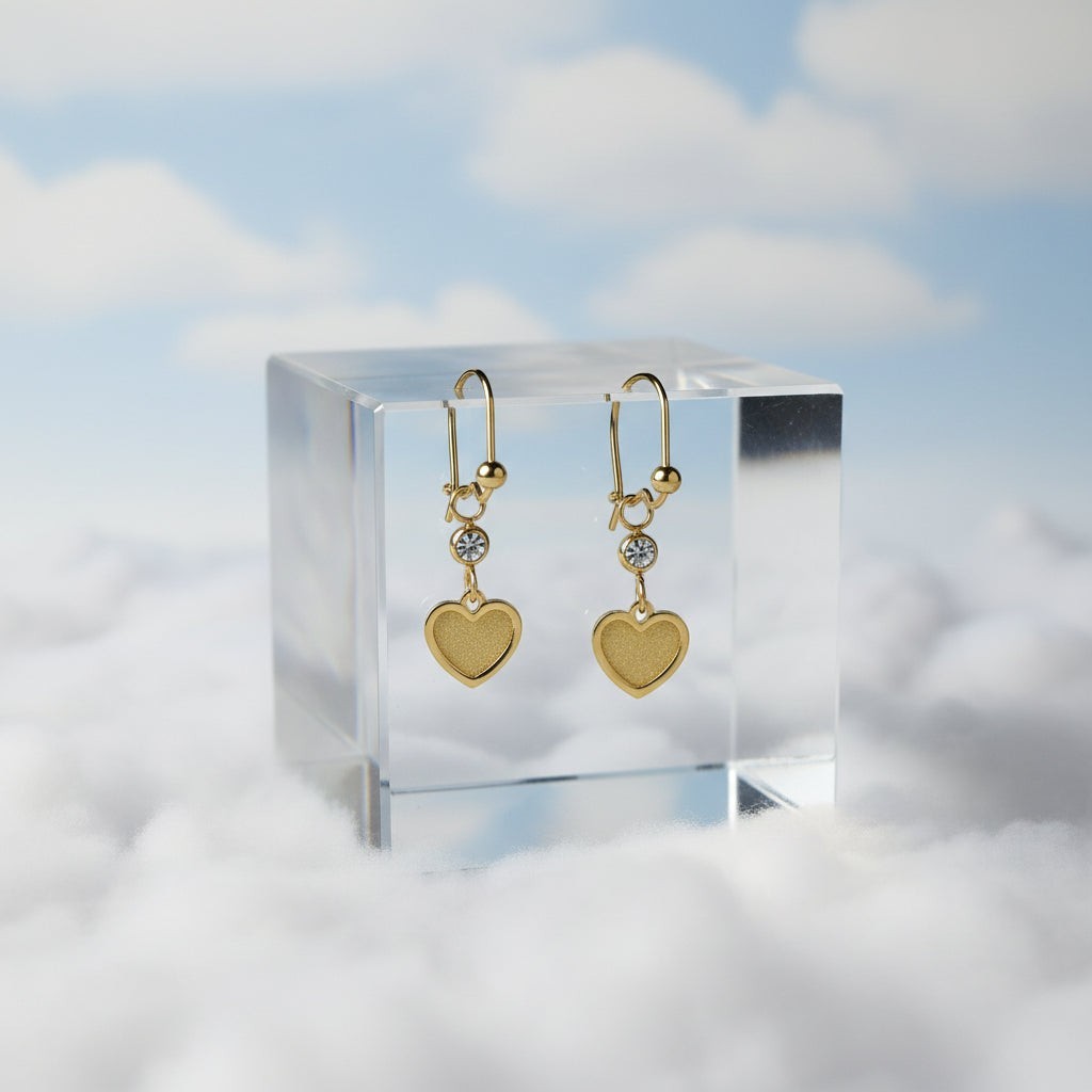 SVORA gold tone stainless steel dangle earrings with heart charms and cubic zirconia accents.
