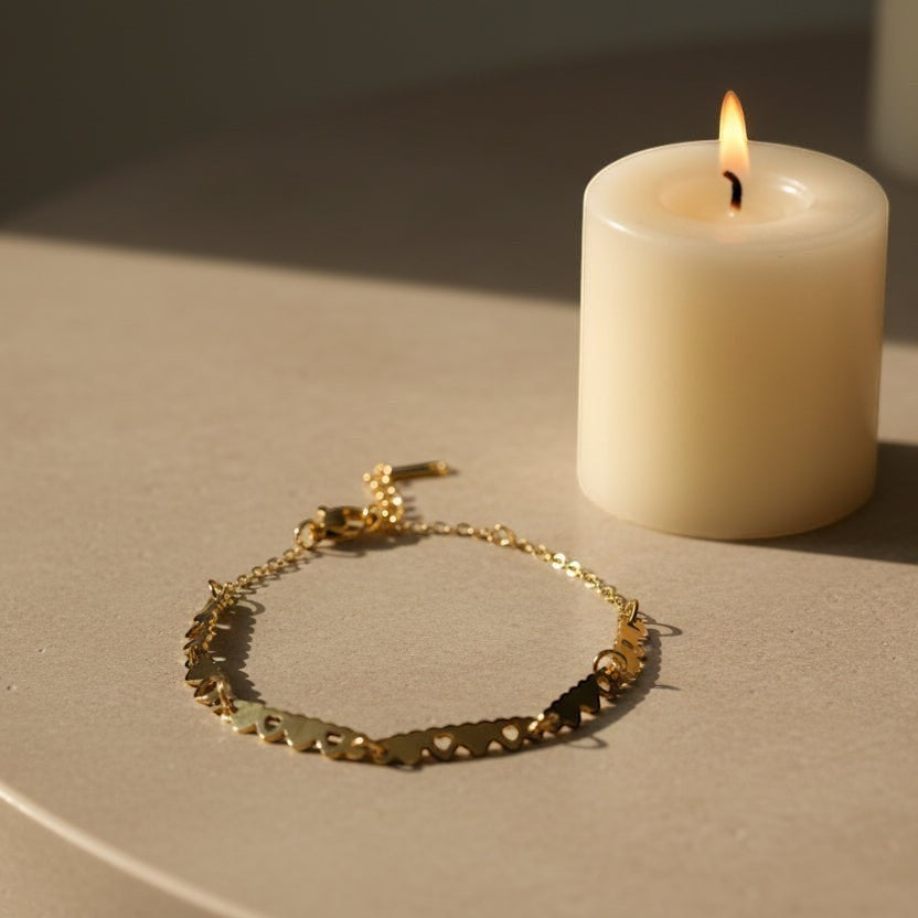 SVORA gold plated stainless steel bracelet with a chain of small linked hearts, adjustable with lobster clasp.