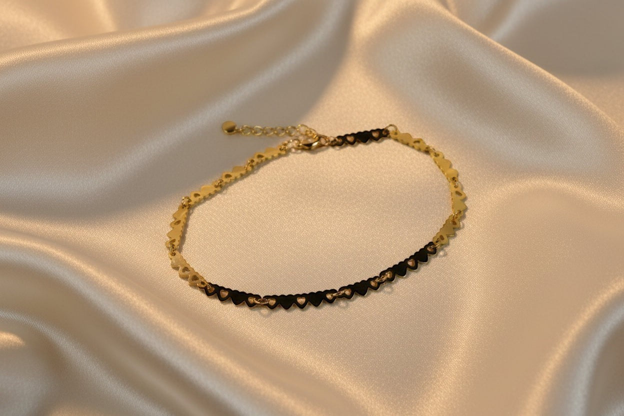 SVORA gold plated stainless steel bracelet with a delicate chain of small linked hearts, adjustable with lobster clasp.