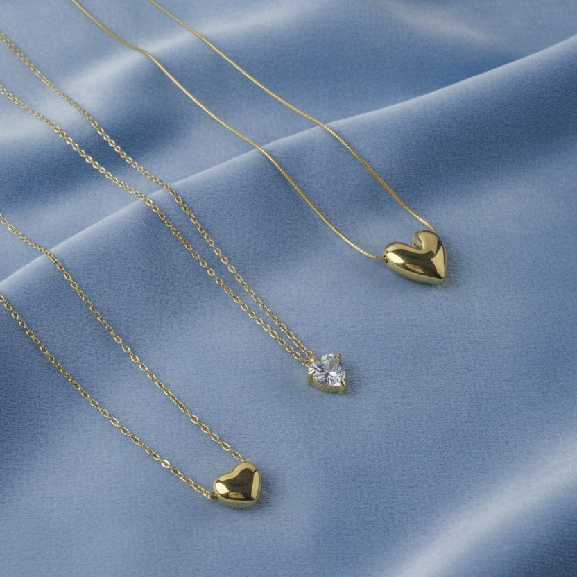 SVORA gold plated stainless steel necklace with a heart-shaped cubic zirconia pendant and two solid gold heart pendants.