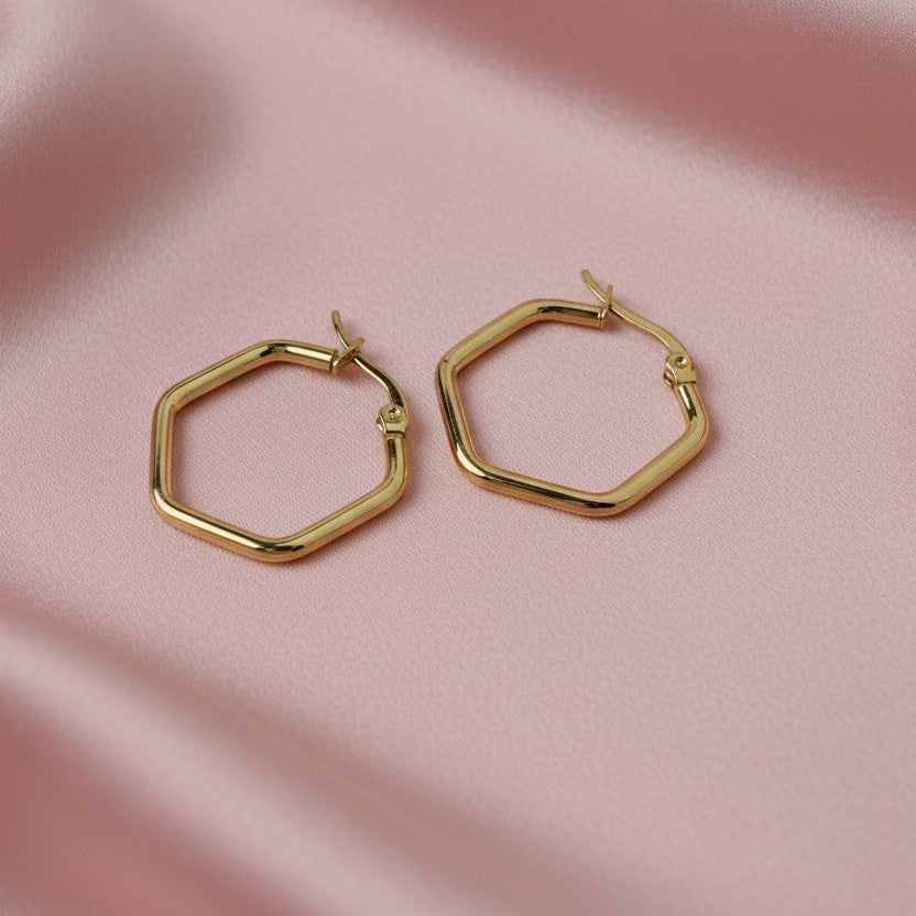 SVORA gold-tone stainless steel hexagon hoop earrings with a polished finish.