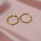 SVORA gold-tone stainless steel hexagon hoop earrings with a polished finish.