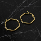 SVORA gold-tone stainless steel hexagon hoop earrings with a polished finish.