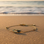SVORA gold plated stainless steel bracelet with interlocking hearts, one black enamel, one with a CZ stone.