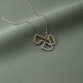 SVORA interlocking triple heart necklace with gold and silver charms on a delicate chain, symbolizing love and connection.
