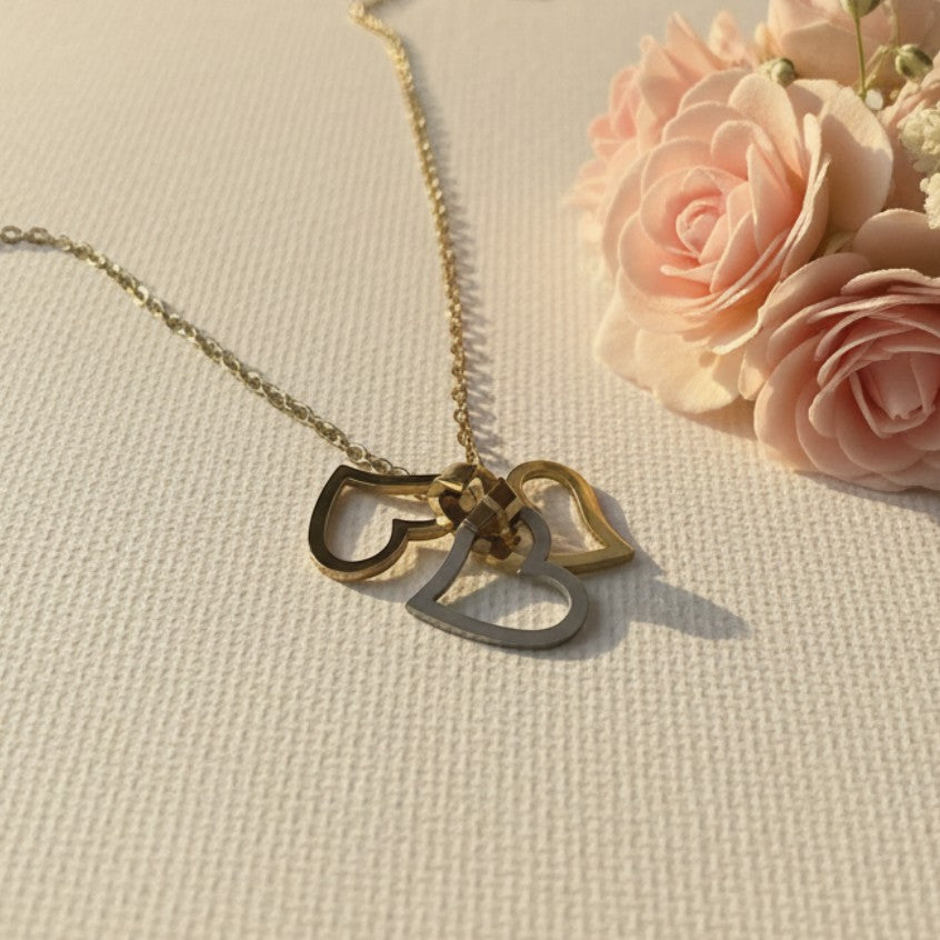SVORA interlocking triple heart necklace in gold-tone stainless steel with a high polish finish.