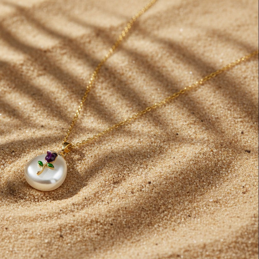 SVORA gold chain necklace with a pearl pendant featuring a small amethyst-purple rose and green leaves.