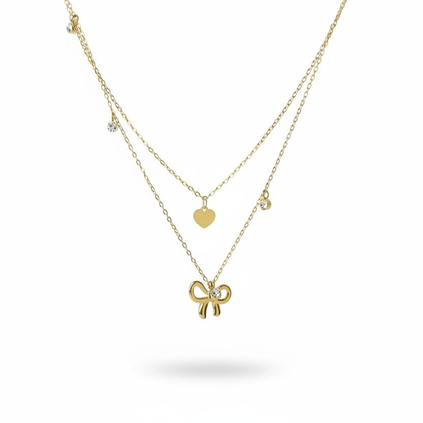 SVORA layered gold-tone stainless steel necklace with bow, heart, and solitaire charms.