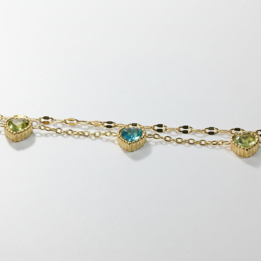 SVORA gold-plated stainless steel layered chain bracelet with green and blue heart-shaped cubic zirconia stones.