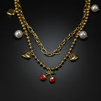 SVORA gold layered necklace with paperclip and ball-bead chains, featuring pearl, heart, and cherry charms.