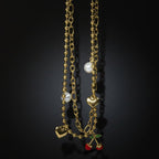 SVORA gold layered necklace with paperclip and ball-bead chains, pearls, hearts, and cherry charm.