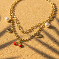SVORA gold layered necklace with paperclip and ball-bead chains, featuring pearl, heart charms, and a cherry pendant.
