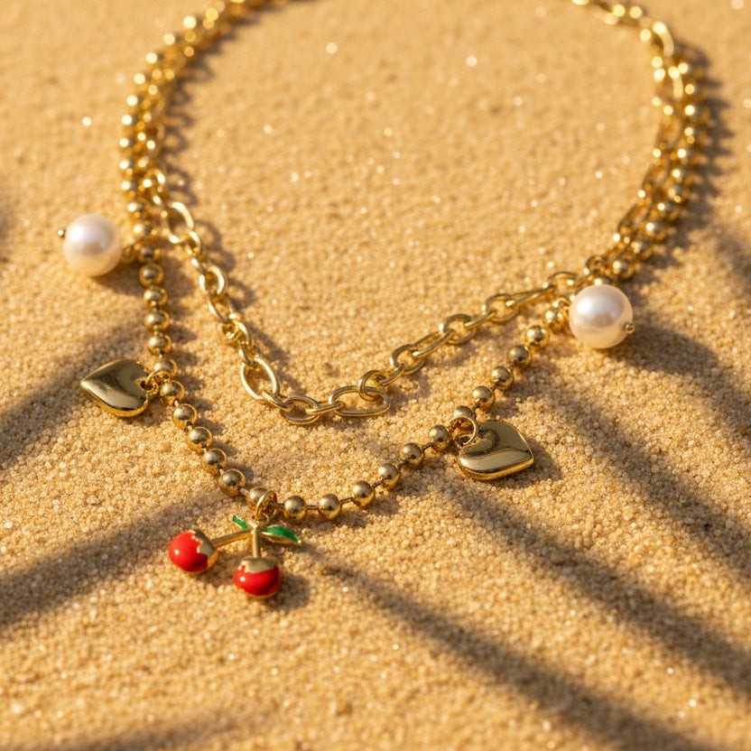 SVORA gold layered necklace with paperclip and ball-bead chains, featuring pearl, heart charms, and a cherry pendant.