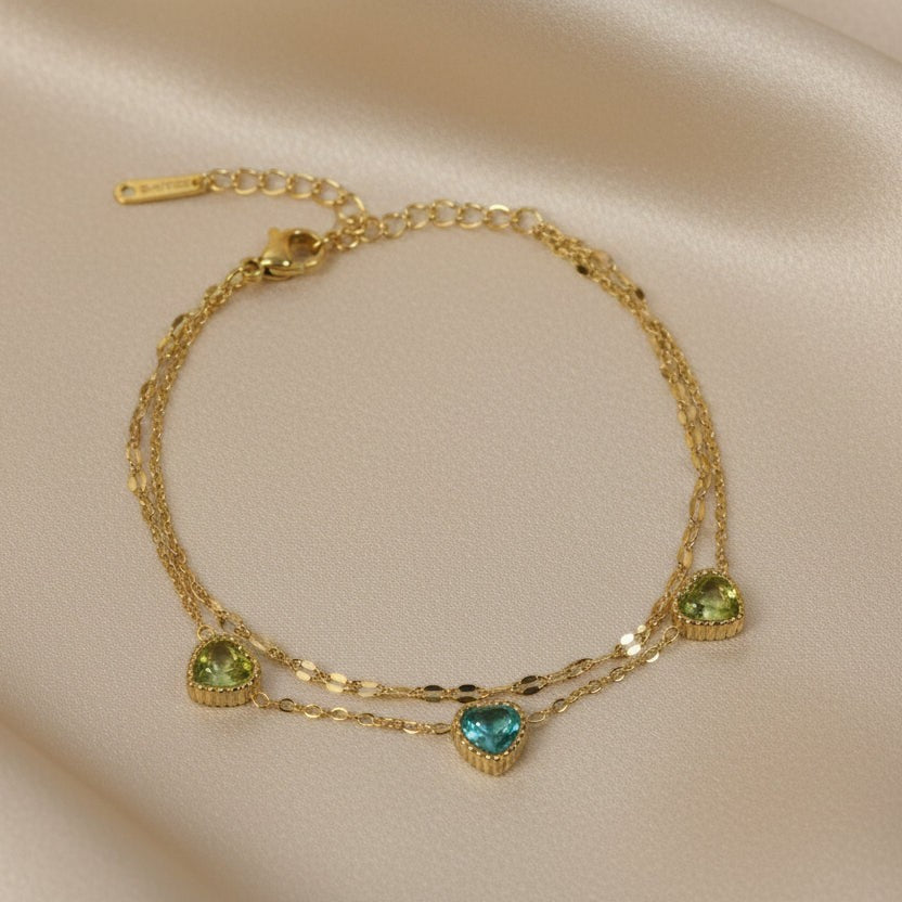 SVORA gold-plated stainless steel layered bracelet with three heart-shaped green and blue cubic zirconia stones.