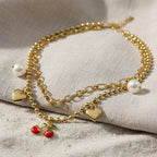SVORA gold layered necklace with paperclip and ball-bead chains, featuring pearl, heart, and cherry charms.