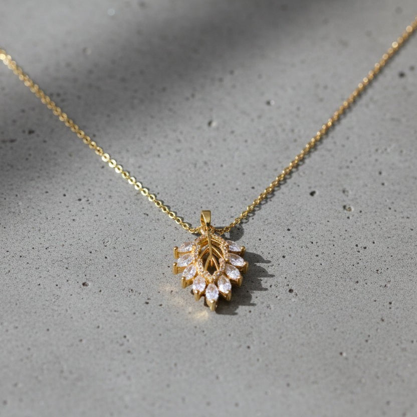 SVORA gold leaf cluster pendant with marquise CZ stones on a delicate chain. Botanical, ornate, modern design.