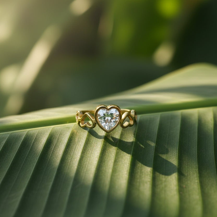 SVORA Lumiere Amour gold plated heart ring with clear stone and heart cutouts on band.