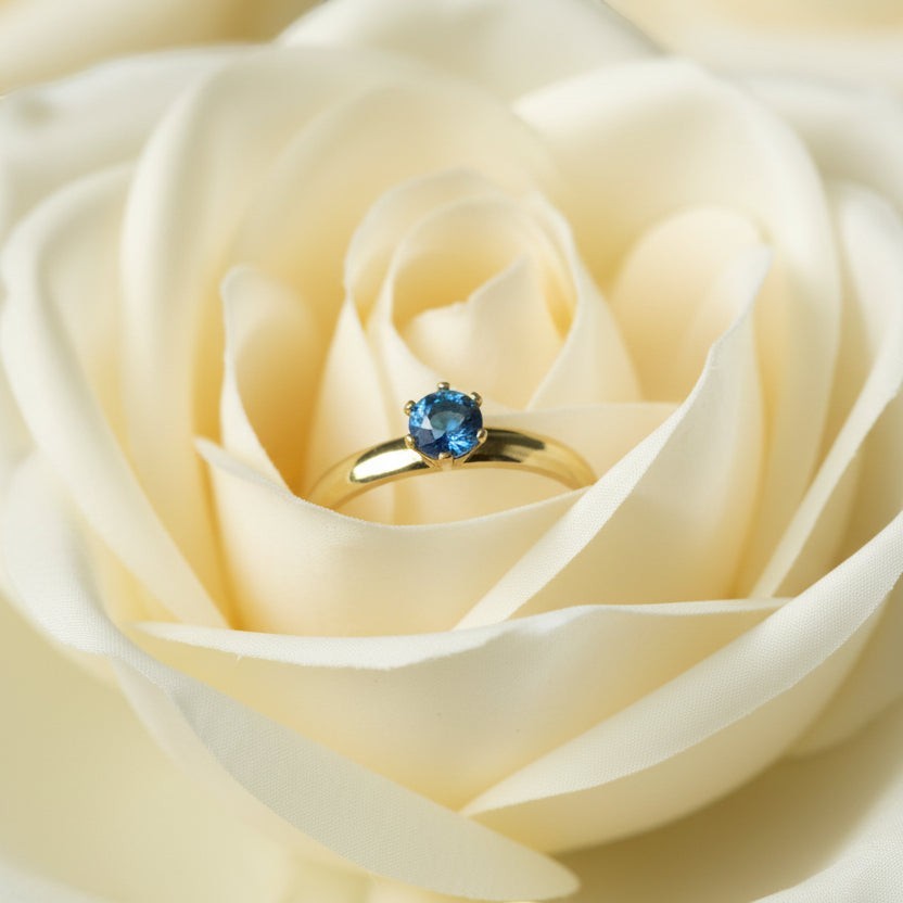 SVORA Lumiere Blue Solitaire Ring with sapphire blue cubic zirconia set in 18K gold plated stainless steel.