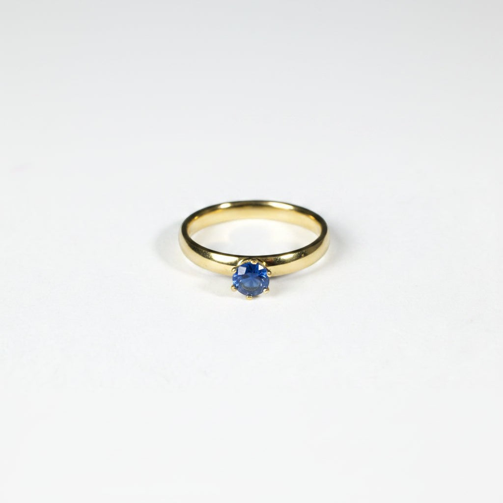 SVORA Lumiere Blue Solitaire Ring with a sapphire blue cubic zirconia set in 18K gold plated stainless steel.