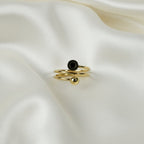 SVORA Lumiere Eclipse Spiral Ring in gold-tone stainless steel with a black accent and a spherical bead.