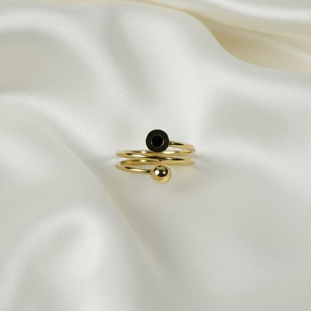 SVORA Lumiere Eclipse Spiral Ring in gold-tone stainless steel with a black accent and a spherical bead.