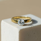 SVORA Lumiere Princess Solitaire Ring in gold-plated stainless steel with a large, clear princess-cut stone.