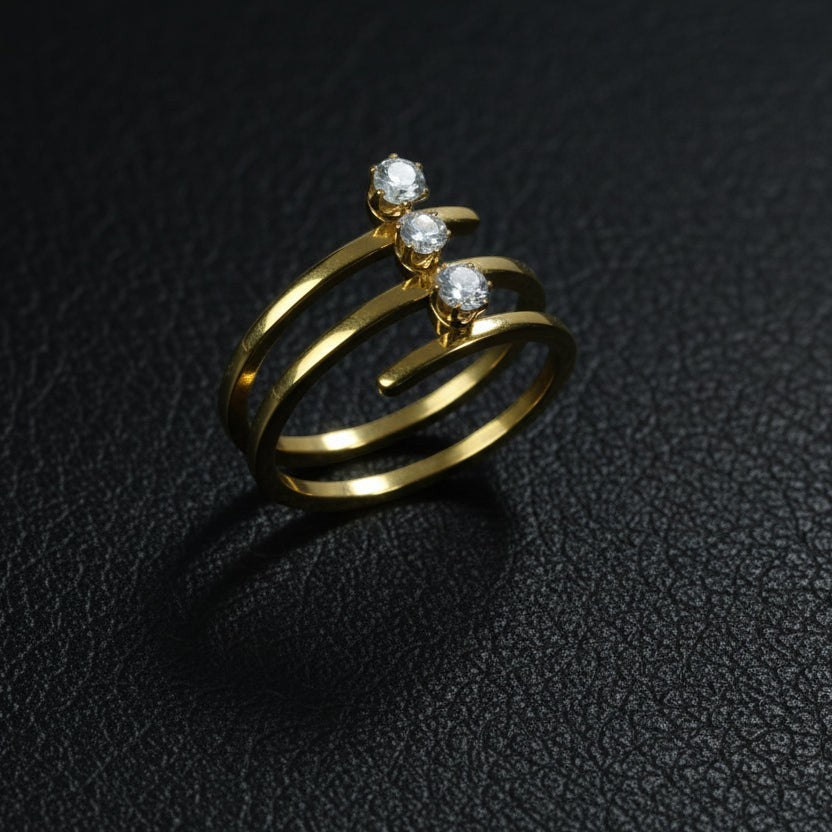 SVORA Lumiere Trilogy Spiral Ring in gold-tone stainless steel with three clear cubic zirconia stones.