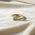 SVORA gold plated stainless steel Lumiere Twist Wrap Ring with pavé-set diamonds and a nail head design.