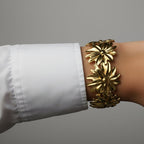 SVORA gold-plated stainless steel Marigold Bloom cuff bracelet with five oversized flower charms.