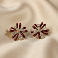 SVORA dark maroon and clear crystal flower stud earrings with gold tone.