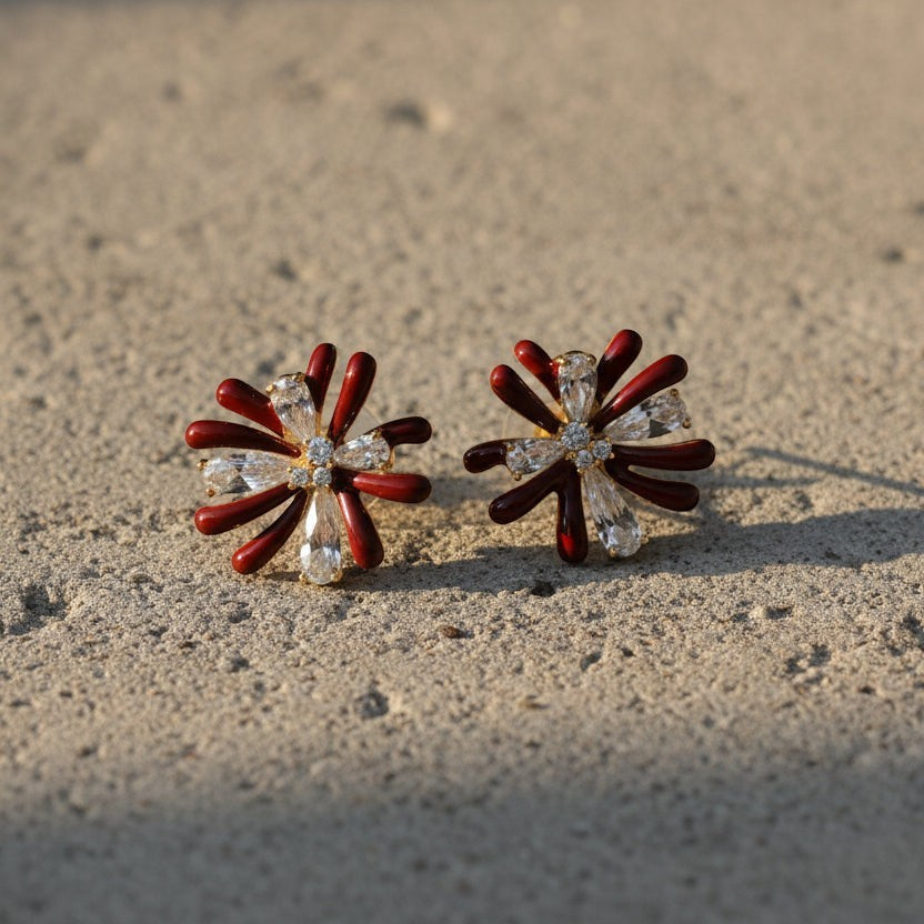SVORA maroon flower crystal stud earrings with alternating dark maroon enamel and clear baguette crystal petals. Gold tone.