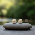SVORA mini gold tone square stud earrings with pavé cubic zirconia and milgrain border, set on a grey stone.