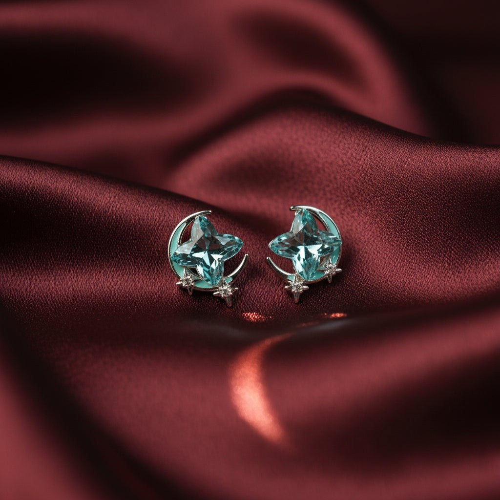 SVORA Moon Aqua Stud Earrings with cushion-cut aqua crystals, crescent moon, and pavé stars. Stainless steel.