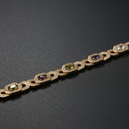 SVORA multicolor halo bracelet with oval CZs in shifting colours on rose gold plated stainless steel. Features hexagonal links and a fold-over clasp.
