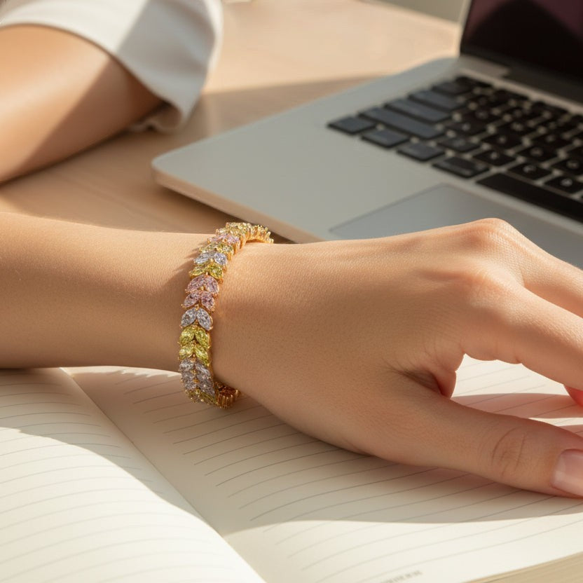 SVORA multicolor pastel tennis bracelet with marquise CZ stones in pink, lavender, and yellow, set in an alternating leaf pattern on a gold-plated stainless steel band.