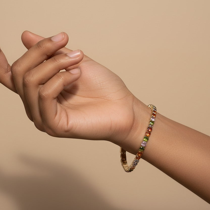 SVORA multicolor tennis bracelet with colorful crystals on a gold-tone stainless steel band, worn on a wrist.