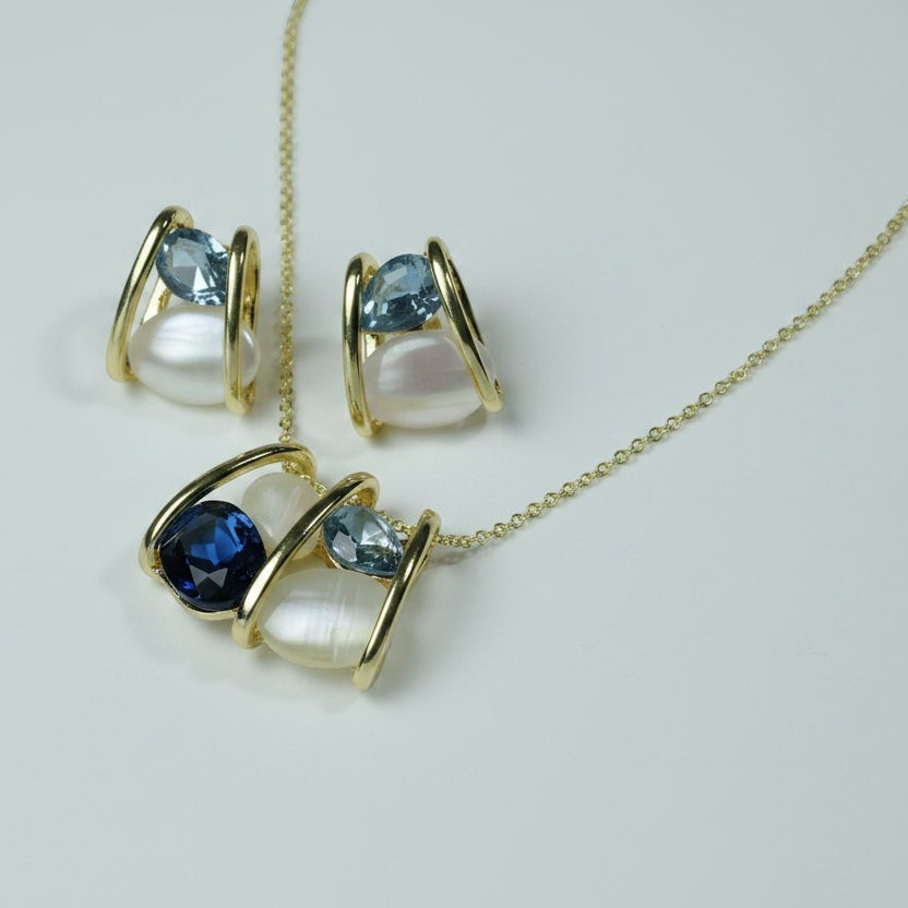 SVORA gold tone necklace and earrings set with navy blue and light blue crystals and white pearls.