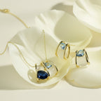 SVORA gold-tone necklace and earrings set with navy and smoky blue crystals and cream cabochons.