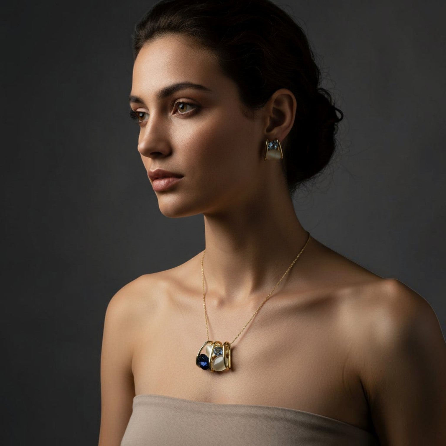SVORA navy and smoky blue crystal cluster necklace and earrings set with cream cabochon in gold tone cage setting.