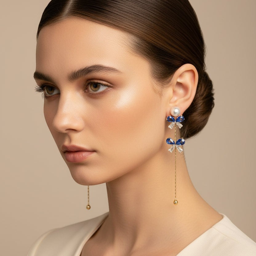 SVORA navy crystal and pearl drop earrings with gold chain and cubic zirconia accents.
