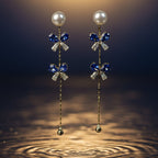 SVORA navy crystal pearl drop earrings with gold chain and cubic zirconia accents.