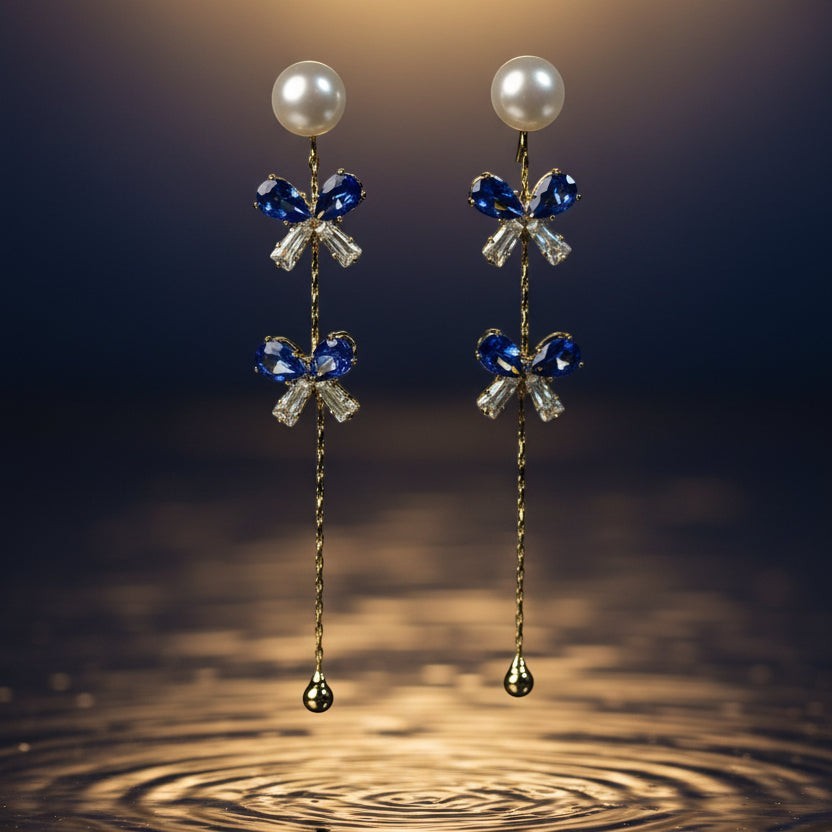 SVORA navy crystal pearl drop earrings with gold chain and cubic zirconia accents.