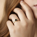 SVORA Noir Clover Lumiere Trefle Ring with black clover motif and crystal white cubic zirconia on a gold-plated band.