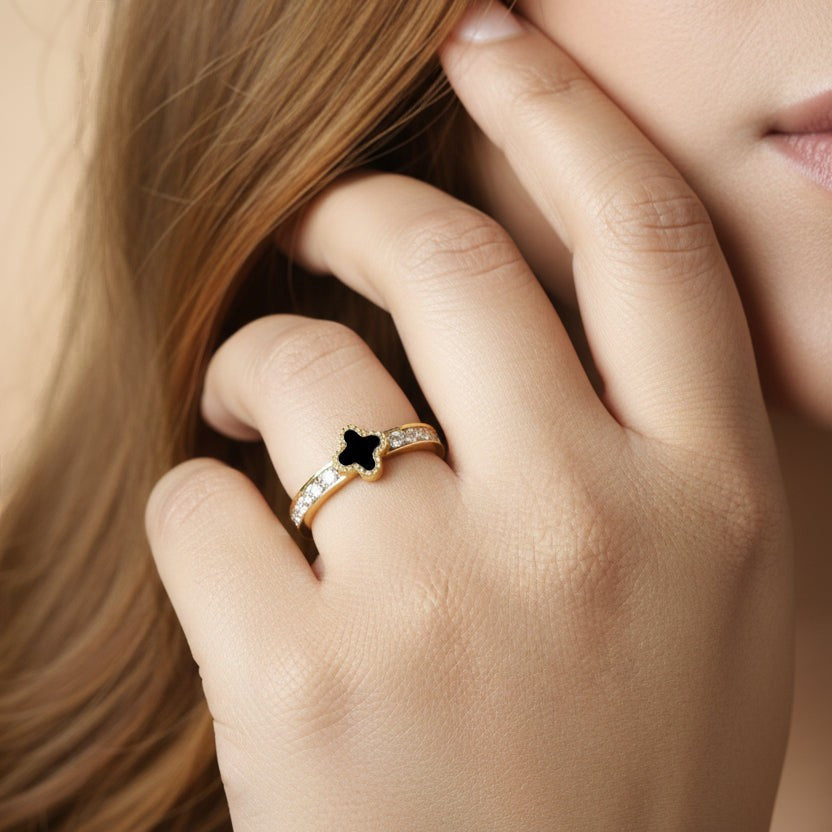 SVORA Noir Clover Lumiere Trefle Ring with black clover motif and crystal white cubic zirconia on a gold-plated band.