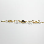 SVORA gold chain bracelet with pearls and a black heart charm. Adjustable lobster clasp closure.