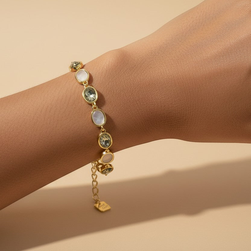 SVORA gold-tone bracelet with alternating opal grey gemstones and a good luck charm, adjustable fit.