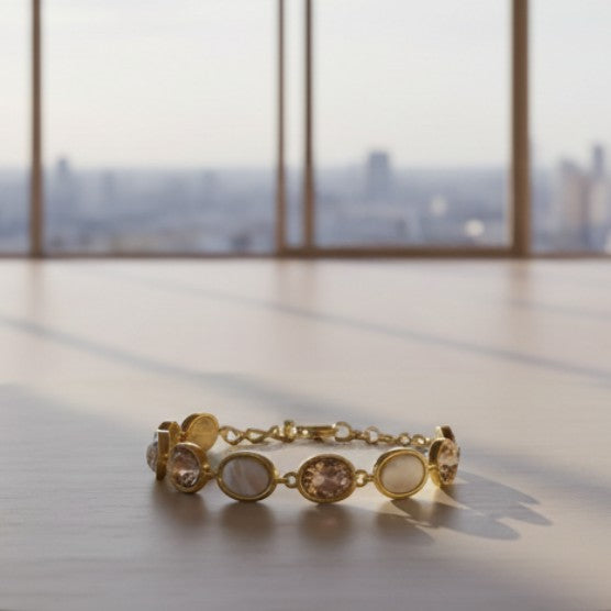 SVORA adjustable gold-tone bracelet with alternating opal and pink gemstones and a good luck charm.