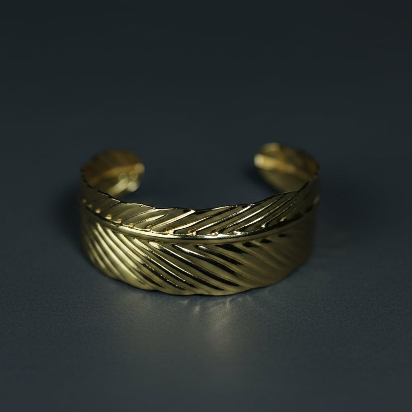 SVORA gold-plated stainless steel cuff bracelet designed as a palm leaf with detailed veins. Adjustable and hypoallergenic.