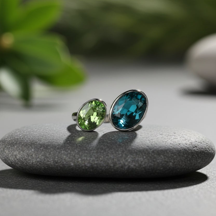 SVORA Toi et Moi Peacock Sapphire Emerald Ring with oval blue and green stones on stainless steel band.