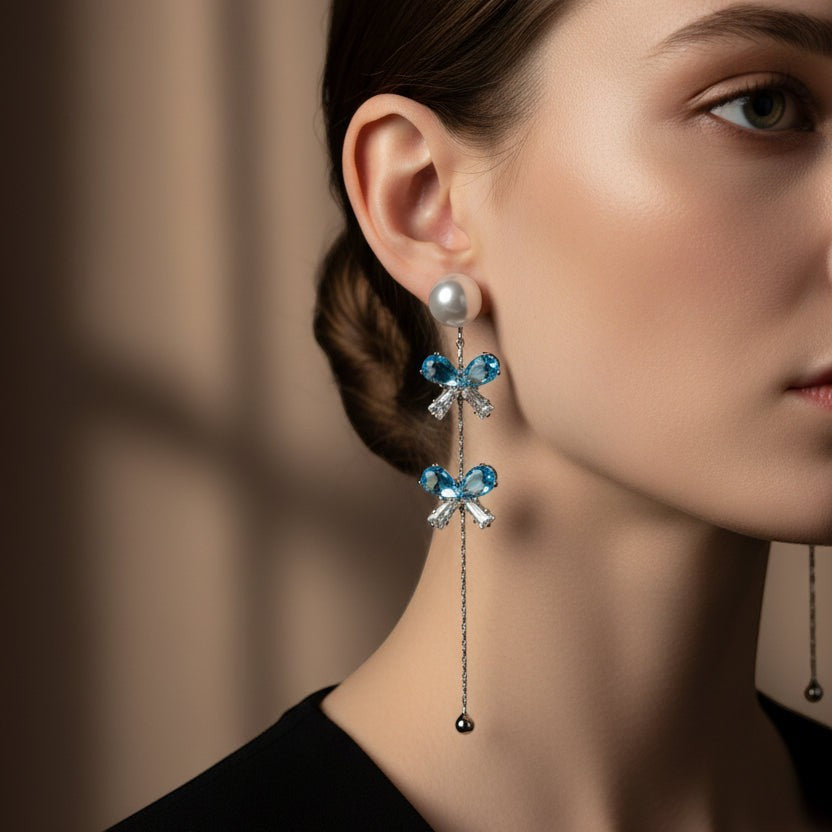 SVORA pearl stud aqua drop dangler earrings with blue crystal bows and cubic zirconia accents.